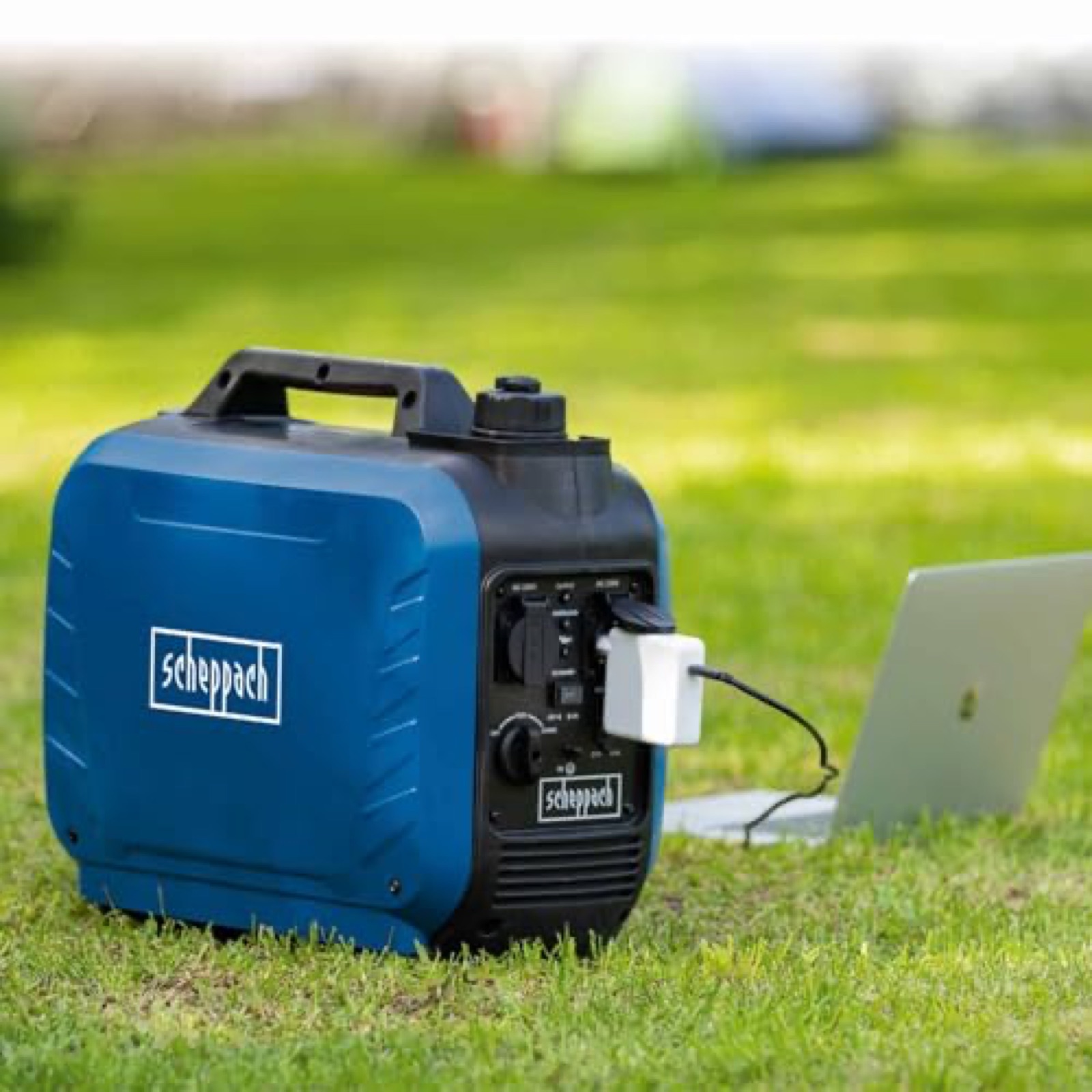 Scheppach SG2500i on the grass, powering a laptop